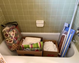Boxes of linens including an applique quilt, table linens and striped placemats