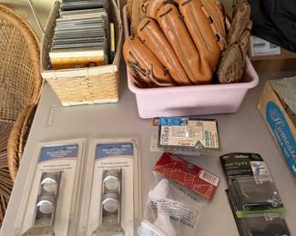 Leather baseball gloves, basket of CDs and packaged door hardware