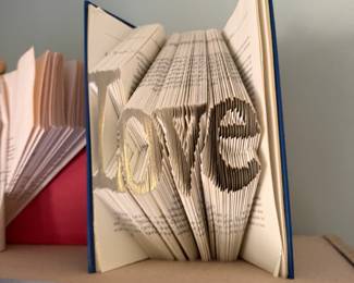 Folded book art spelling Love
