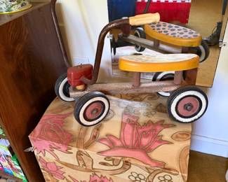 Vintage wood and metal ride-on toy on a floral painted wooden trunk