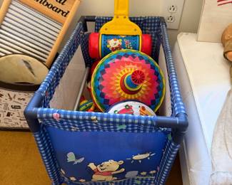 Winnie the Pooh portable play yard with a corn popper push toy and colorful tin toys