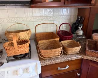 Collection of woven splint baskets, a red painted basket, a glass canister and a rattan box