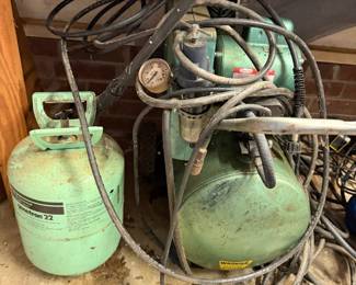 Air compressor with hoses and a refrigerant tank