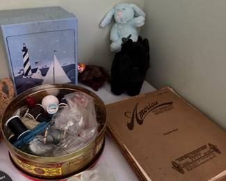 Sewing tin with thread, antique sheet music folio, plush toys and a lighthouse print box
