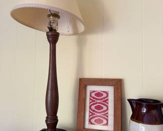 Turned wood table lamp, framed red needlework and brown and cream stoneware pitcher