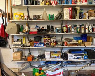 Garage shelving packed with hardware, paint, automotive supplies, Chilton manuals and bags of soil