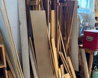 Stack of lumber, plywood and trim boards with a vintage red Coleman cooler