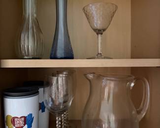 Glass bud vases, twisted stem wine glasses, a glass pitcher and travel tumblers