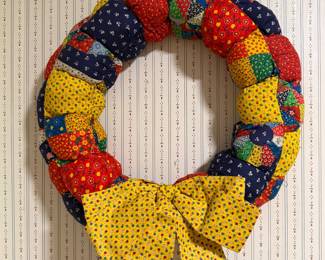 Handmade quilted puff fabric wreath with a yellow calico bow