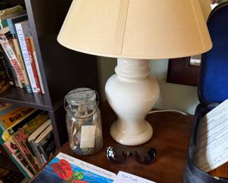 White ceramic table lamp with Eric Carle children's books and a glass storage jar