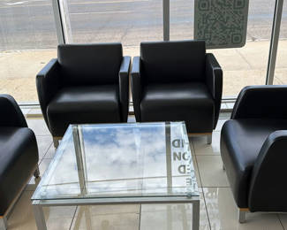 Lot 77: Four Black Armchairs and Glass Coffee Table