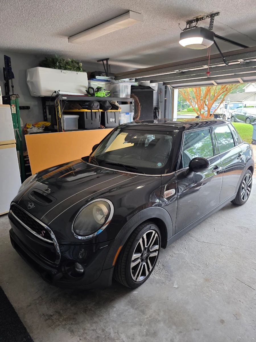 MINI Cooper hatchback in dark gray with black roof and white hood stripes