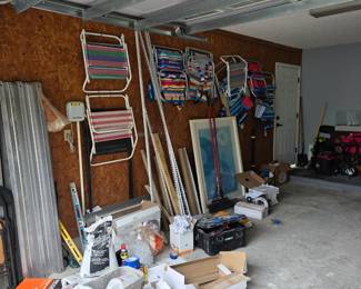 Garage wall of folding striped beach chairs, framed print and tools