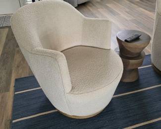 Cream boucle barrel swivel chair with wood base and drum side table