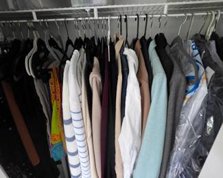 Closet of clothing with striped sweater, blouses and jackets