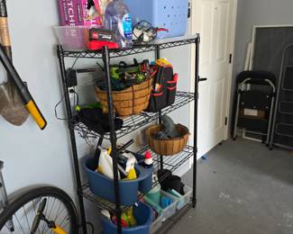 Black wire shelving unit with garden tools, baskets and supplies