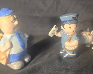Mailmen & Dogs Shaker Set 4pc set All porcelain Blond mailman is 4.25" tall Corresponding dog is 2" tall Has slight crazing Black haired mailman is 3.25" Corresponding dog is 1.75" They have magnets that attach them