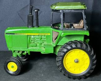 Vintage John Deere Die-Cast Metal Tractor Toy Shows some signs of wear like broken plastic and paint chipping See photos for condition and measurements Stamped with 0954 on the bottom