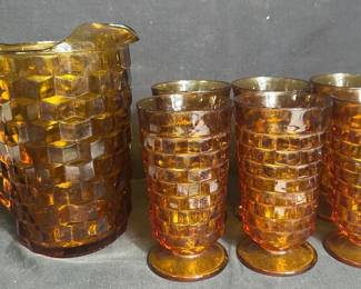 Vintage Indiana Glass Amber Whitehall Pitcher & Tumblers Vintage Indiana Glass Whitehall beverage set in warm amber glass, featuring the distinctive geometric cube pattern. Includes one pitcher and six matching footed tumblers.  7 pieces total 1 pitcher 6 footed tumblers Amber pressed glass See photos for condition and measurements Market Insight & Estimated Market Value: The Whitehall pattern is a classic of vintage American glassware, and the rich amber color makes this complete beverage set especially attractive for serving or display.  Estimated Market Value: $45–$70