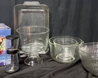 Assorted Glass Bakeware, Mixing Bowls & Trifle Bowl Useful assortment of kitchen and serving pieces including clear glass mixing/baking bowls, a footed trifle bowl with box, hand-crank measuring dispenser, and Anchor Hocking glass baking dish.  Assorted clear glass kitchenware Includes nested/mixing bowls and serving pieces Footed trifle bowl includes original box Anchor Hocking baking dish Hand-crank measuring dispenser Please see photos for items included and condition   Market Insight & Estimated Market Value: A practical kitchen lot with pieces for baking, mixing, food prep and entertaining.    Estimated Market Value: $35–$55