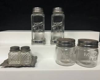 Rustic Glass Salt & Pepper Shaker Collection Three decorative salt and pepper shaker sets combining clear glass with silver-toned accents. Includes miniature pressed-glass shakers with an ornate tray, mason jar-style shakers, and a taller dragonfly-accented set.  3 sets / 6 shakers total Ornate silver-toned tray included Dragonfly and floral detailing Mason jar-style glass pair Please see photos for measurements and condition   Market Insight & Estimated Market Value: A versatile collection with farmhouse, cottage, and nature-inspired appeal, ready for kitchen display or table use.    Estimated Market Value: $25–$40