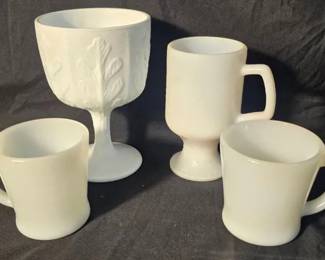 Vintage Fire-King & Milk Glass Drinkware Four-piece white milk glass assortment with a nice mix of vintage Fire-King and decorative drinkware.  2 Anchor Hocking Fire-King Oven-Proof mugs 1 footed Irish coffee mug 1 FTD footed oak-leaf goblet/candy dish Pieces need cleaning See photos for condition and details   Market Insight & Estimated Market Value: Classic white milk glass is easy to display and collect, with the marked Fire-King mugs adding extra appeal to this mixed group.    Estimated Market Value: $25–$40