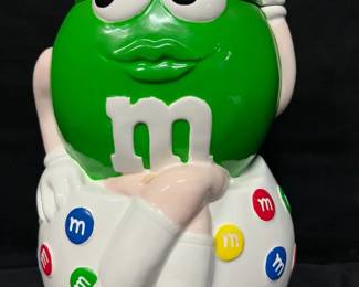 Vintage Green M&M Character Cookie Jar Fun Green M&M character cookie jar featuring her classic white boots and colorful M&M candy accents. The large figural design makes this a great display piece for an M&M collection, kitchen, or game room.  Removable Green M&M lid Ceramic construction Believed to be vintage Please see photos for measurements and condition   Market Insight & Estimated Market Value: M&M character collectibles have a strong nostalgic following, and the large figural cookie jars make especially fun display pieces.    Estimated Market Value: $30–$50
