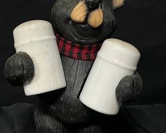 Rustic Black Bear Salt & Pepper Shaker Holder Whimsical rustic black bear figurine designed to hold the included white ceramic salt and pepper shakers. A fun accent for a cabin, lodge, farmhouse kitchen, or bear-themed collection.  Bear appears to be resin Includes 2 white ceramic shakers Bear wears a red and black plaid scarf See photos for measurements and condition   Market Insight & Estimated Market Value: A cute and functional countertop piece with strong cabin and lodge décor appeal.    Estimated Market Value: $20–$35