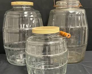 Vintage Barrel-Shaped Glass Storage Jars With Lids Set of three clear glass storage jars with a fun barrel shape and paneled design. Two retain screw-on lids, while two jars feature wire handles with wooden grips. Great vintage kitchen or pantry storage with plenty of decorative appeal.  3 jars total Two larger jars approx. 13"H No noticeable chips or cracks Vintage wear and discoloration to lids/hardware Please see photos for condition and details Market Insight & Estimated Market Value: The barrel shape, heavy glass, and wooden-handled hardware give these more character than ordinary storage jars—great for a vintage kitchen, pantry, or farmhouse display.  Estimated Market Value: $40–$65