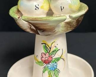 Vintage Bird Salt & Pepper Shakers With Spoon Nest Charming vintage ceramic kitchen set featuring two bird salt and pepper shakers perched in a floral pedestal “Spoon Nest.” A fun retro display piece that keeps shakers and cooking spoons together.  Both shakers retain their stoppers No noticeable chips or cracks See photos for condition and details Market Insight & Estimated Market Value: The unusual all-in-one spoon rest and shaker design gives this set extra vintage kitchen charm and display appeal.  Estimated Market Value: $25–$40