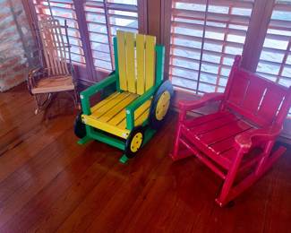 three children's rockers including a bentwood twig rocker, one in the shape of a John Deere tractor, and a traditional red rocker