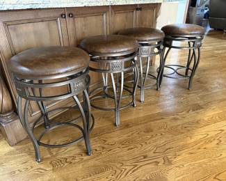 4 modern swivel stools featuring metal frames with leather seats