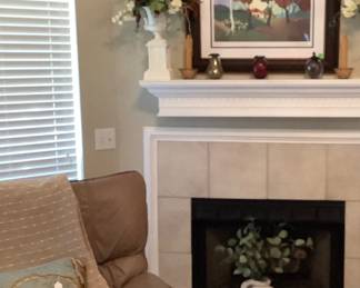 The beautiful mantle decorated and the white tall bottle on hearth.