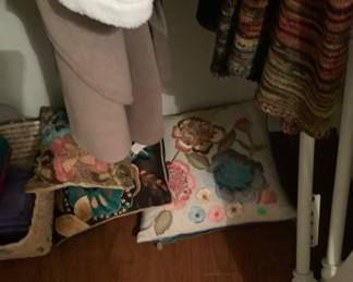 More clothes and decorative pillows.