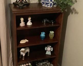 4 shelf mahogany bookcase with lamp, books, blue & white vase with greenery.