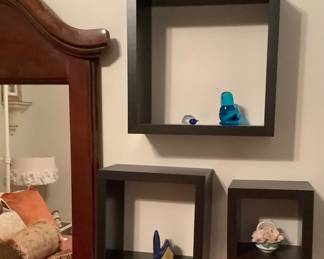 3 black hanging boxes with decorative items.