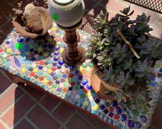 Coffee table with colored glass beads with candle and live plant.