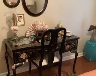 Oriental desk and chair with gorgeous birds and flowers.  Above are two round mirrors.