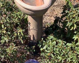 Another bird bath with bird, with blue ball on stand