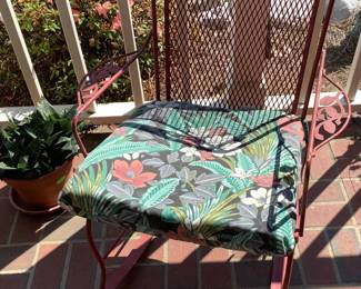 Red metal chair with cushion.
