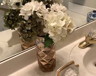 Flower arrangement in bathroom with a Angel wall shelf.