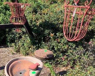 2 red metal plant hangers.