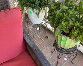 2 metal plant stands with live plants in pretty pots.