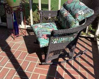 Black wicker rocker with cushions.
