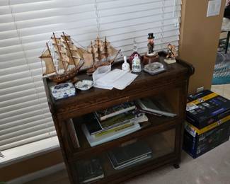 Wood side table with model ships, books and decor