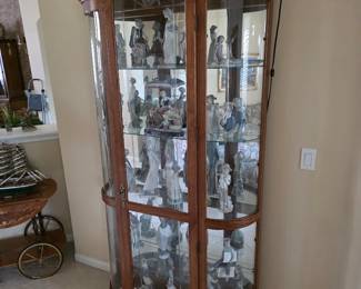 Curved-glass curio cabinet with glassware collection