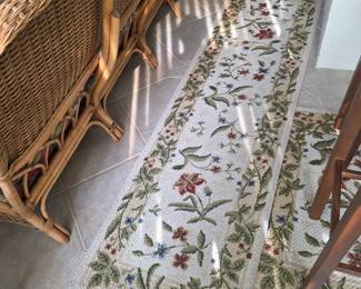 Floral runner rug beside rattan furniture