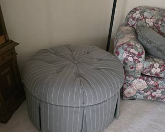 Tufted round ottoman with floral armchair and floor lamp
