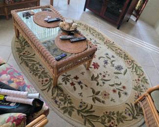 Oval floral area rug with rattan coffee table and sofa