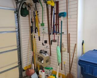 Garage wall with yard tools, brooms and rakes
